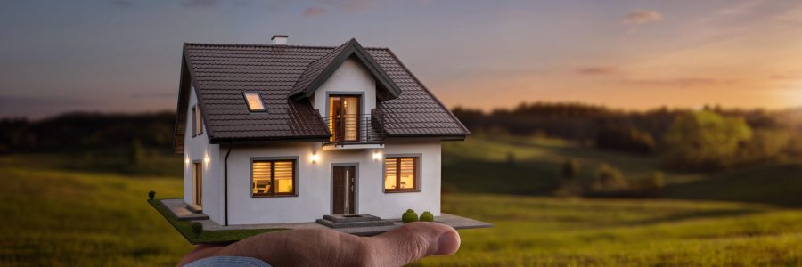 Concept of buying or building a new home. Male hand showing, offering a new dream house at the empty field with copy space